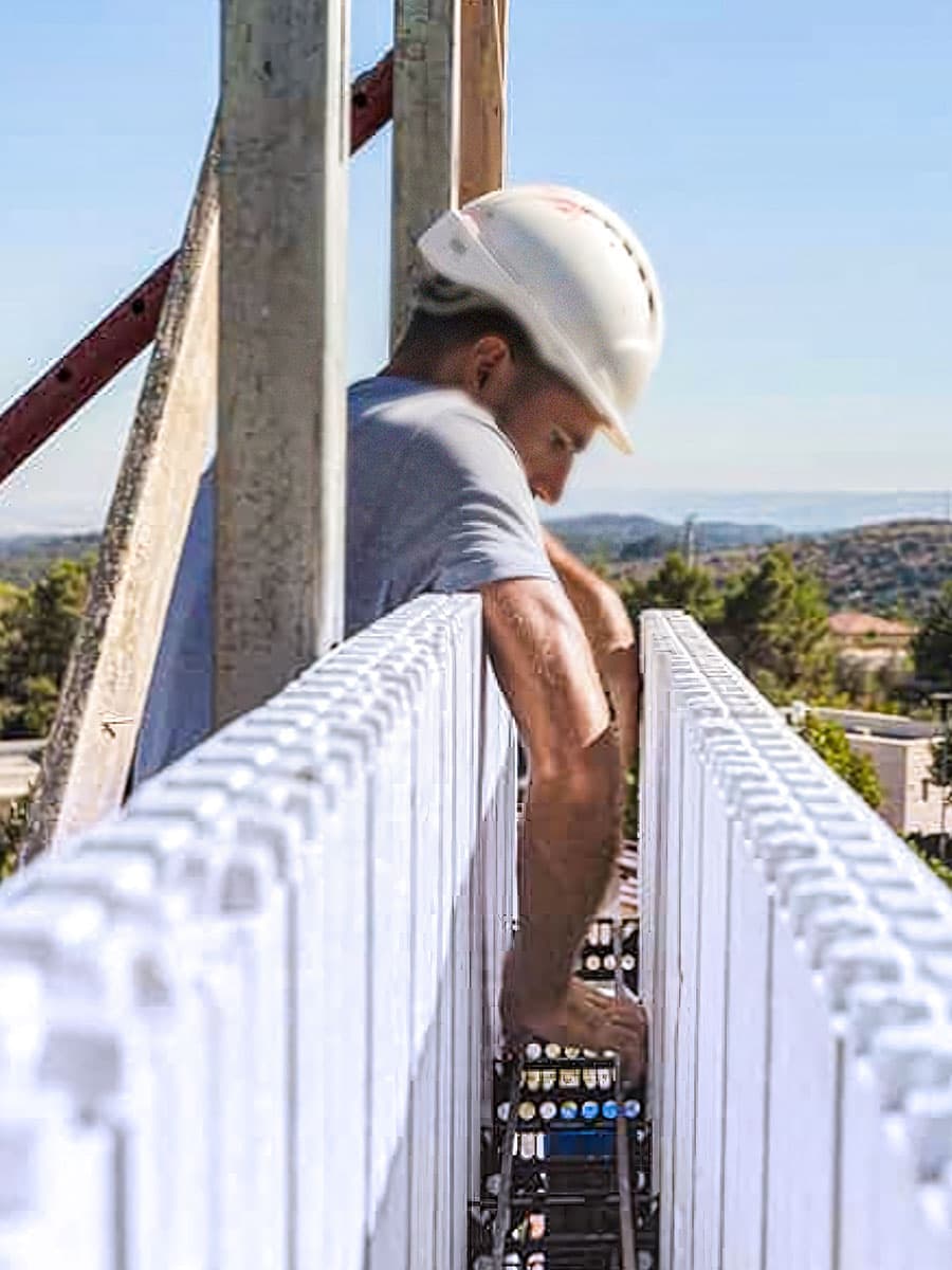 Operaio installa i distanziali del pannello ICF a parete